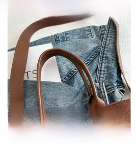 Close-up of brown suede tote bag featuring high-quality stitching and textured shoulder strap