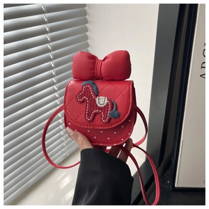 Detail of red quilted child crossbody bag with 3D bow and embroidered pony motif