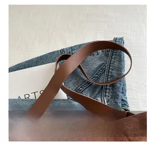 Detail of comfortable dark brown leather shoulder strap on a large casual tote bag
