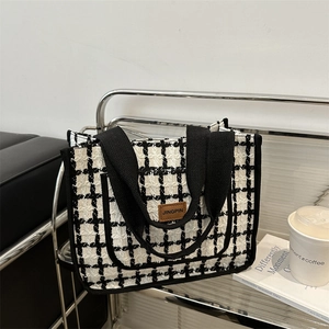 Chic black and white plaid tweed tote bag with a premium leather patch and sturdy handles
