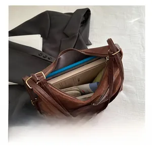 Detailed top view of a large brown tote showing books and a tablet inside for high capacity