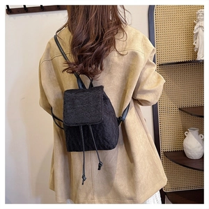 Detail view of black faux fur backpack texture on a beige coat with stylish drawstring
