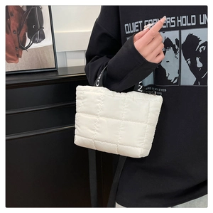 Detailed shot of white quilted padded tote bag with black lettered woven handles
