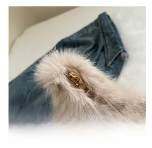 Détail de la fermeture éclair en métal doré sur un sac à bandoulière en fausse fourrure douce