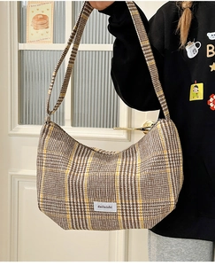 Detailed close-up of the vintage plaid dumpling bag with a retro white logo patch