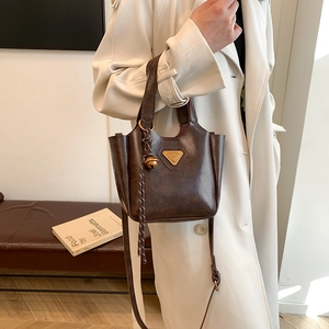 Vintage brown PU leather bucket tote bag with gold metal logo and crossbody strap