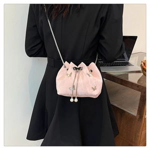 Sac seau rose à cordon avec breloques papillon et détails de perles sur chaîne métal