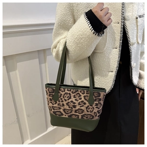Detail of leopard print plush and dark green leather panels on a large tote bag