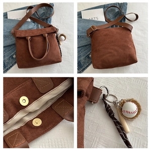 Detailed view of brown faux suede tote with magnetic closure and baseball charm accessories