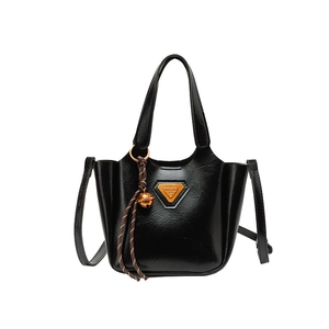 Minimalist black glossy leather tote bag with triangle logo and bell charm pendant