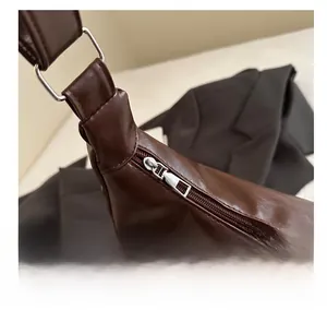 Detail showing smooth silver zipper and stitching on dark brown PU leather tote bag