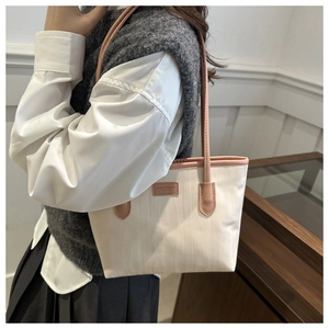 Close-up of the cream tote bag with vertical wave texture and pink leather straps