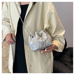 Détail du sac bandoulière argenté plissé avec papillons en métal et perles