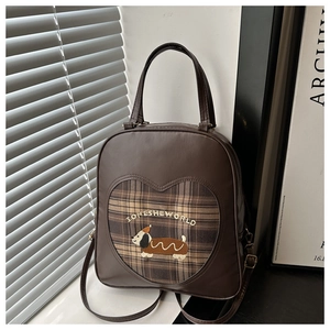 Dettaglio dello zaino vintage marrone con ricamo bassotto e finestra a forma di cuore