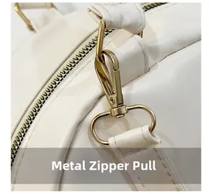 Close-up of golden metal zipper and detachable strap hook on white leather backpack
