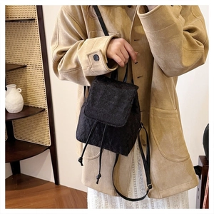 Detail view of black faux fur backpack with drawstring closure and slim leather straps