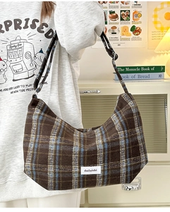 Detail of vintage brown plaid wool shoulder bag with minimalist label and warm texture