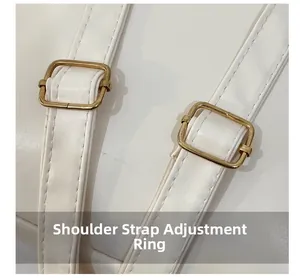 Close-up of adjustable golden shoulder strap buckles on a white leather backpack