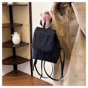 Detail view of black faux fur backpack with soft plush texture and elegant drawstring closure