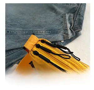 Detail view of the smooth three-layer zipper design on this bright yellow nylon crossbody bag