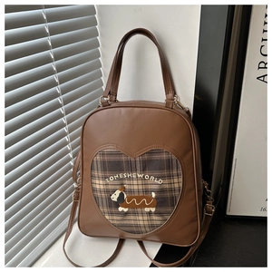 Dettaglio zaino vintage marrone con trapuntatura a cuore e ricamo a forma di cane