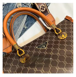 Detailed close-up of retro brown monogram tote with golden shell swan hardware