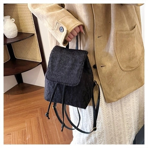 Detail of black faux fur mini backpack with soft texture and leather strap in lifestyle setting