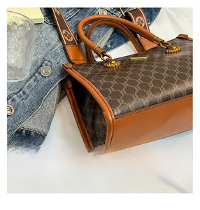 Close-up of vintage doctor bag featuring retro floral pattern and textured gold hardware