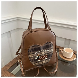 Dettaglio dello zaino vintage marrone con ricamo a cucciolo e finestra a cuore