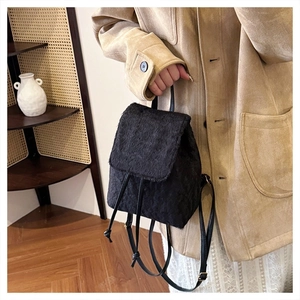 Close-up of black plush backpack featuring a soft faux fur texture and drawstring flap closure