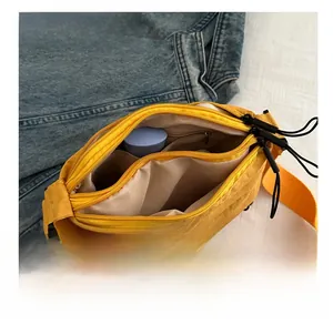 Detail showing the spacious main compartment and inner pocket of this yellow crossbody bag