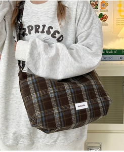 Detail view of vintage plaid dumpling bag with shoulder strap and dailaishi cloth label