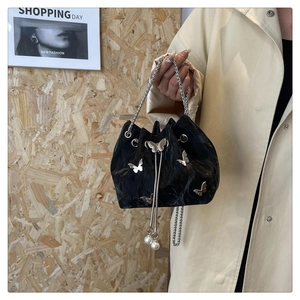 Détail du sac à cordon noir plissé avec papillons argentés et accents de perles