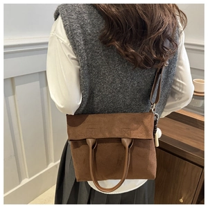 Brown suede-like tote bag shown in real-life use with a cute white ball charm decoration