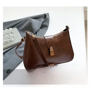 Détail du sac croissant marron foncé vintage avec ferrures dorées et fermoir tournant