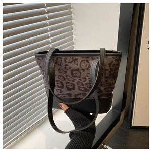 Detailed view of leopard print tote bag with soft suede texture and black leather handles