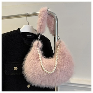Détail d'un sac demi-lune en fausse fourrure rose avec chaîne en perles et anse peluche
