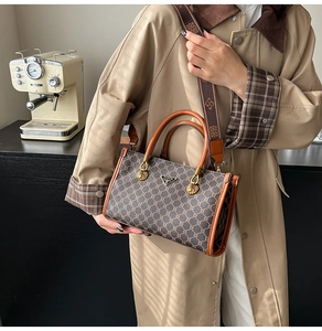 Close-up of vintage tote bag with retro patterns, round handle and gold hardware detail