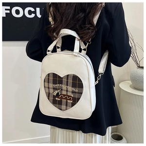 Rear view of a white leather backpack featuring a heart pattern and cartoon puppy design