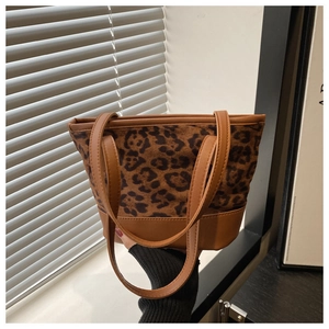 Close-up of leopard print tote bag with brown leather details and dual handle design