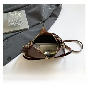 Vue intérieure du sac demi-lune en cuir marron montrant l'espace pour le téléphone