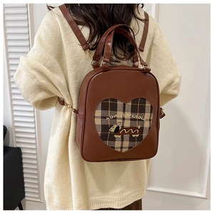 Brown vintage backpack with heart pattern and cartoon puppy embroidery shown on model
