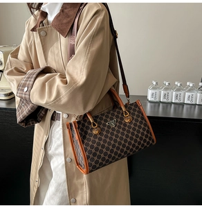 Detail of vintage monogram canvas tote with gold seashell hardware and leather trim