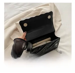Vue macro d'un sac bandoulière matelassé noir montrant sa capacité et sa fermeture aimant