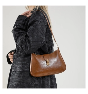 Détail du sac croissant en cuir marron vintage avec boucle en métal chic