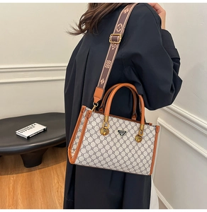 Detail of vintage monogram tote bag with brown leather trim and wide jacquard strap