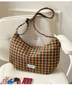 Detailed macro shot of the colorful houndstooth texture and logo label on the dumpling bag