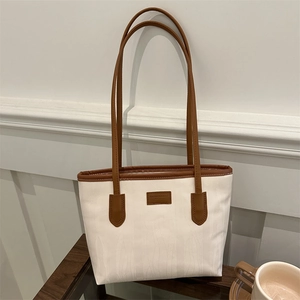 Large capacity cream tote bag with brown leather trim and textured fabric for commuting