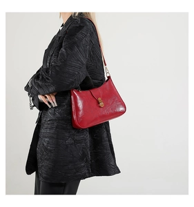 Détail d'un sac demi-lune bordeaux vintage avec cuir ciré et boucle en métal doré
