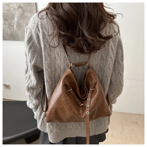 Detailansicht einer braunen Vintage-Leder-Hobotasche mit Bronzeschnallen und Kordelzug